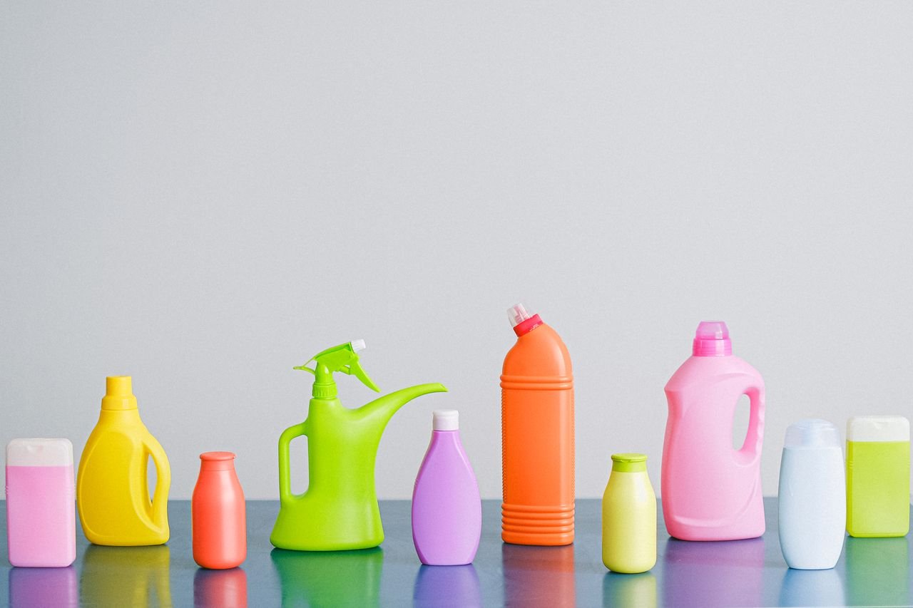 Services Arrangement of colorful plastic bottles with assorted cleaning products for household placed on table in row against white background in light studio
